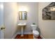 Cozy powder room with a pedestal sink, toilet, and decorative mirror at 10090 Jones Bridge Rd # 2, Alpharetta, GA 30022