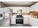 Bright kitchen with stainless steel refrigerator and range, complemented by white cabinets at 3001 Majestic Park Ct, Duluth, GA 30096