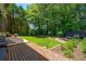 This large backyard showcases a spacious deck and lush, green lawn surrounded by trees at 3680 Milton Park Dr, Alpharetta, GA 30022