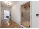 Hallway view into bathroom featuring glass shower with tile surround and floors at 3680 Milton Park Dr, Alpharetta, GA 30022