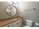 Bathroom featuring a round mirror, vanity, toilet, and glass shower at 3680 Milton Park Dr, Alpharetta, GA 30022