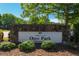 Stone Johns Creek Ocee Park community sign nestled among green bushes and a shade tree at 3680 Milton Park Dr, Alpharetta, GA 30022