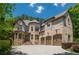 Stunning brick home featuring a three car garage and well-manicured landscaping at 3680 Milton Park Dr, Alpharetta, GA 30022