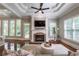 Cozy living room with a fireplace, large windows, and hardwood floors at 3680 Milton Park Dr, Alpharetta, GA 30022