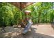 Community playground with tan shade awning and slide surrounded by green trees at 3680 Milton Park Dr, Alpharetta, GA 30022