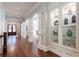 Grand foyer with dark hardwood floors, white pillars, arched doorways, and built-in display cabinets at 44 Barbara Ln, Atlanta, GA 30327