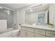 Bathroom with tub/shower combo, tile surround, toilet, white vanity with chrome faucet and large mirror at 1059 Woodland Ave, Atlanta, GA 30316