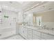Gorgeous bathroom with a large glass shower, white marble counters and double sink vanity at 1059 Woodland Ave, Atlanta, GA 30316
