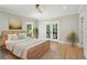 Calm bedroom with french doors, hardwood floors and neutral decor at 1059 Woodland Ave, Atlanta, GA 30316