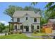 Charming two-story home with a manicured lawn, stone walkway, and a lovely pergola covered porch at 1059 Woodland Ave, Atlanta, GA 30316