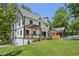 Charming two-story home with a manicured lawn, stone walkway, and a lovely pergola covered porch at 1059 Woodland Ave, Atlanta, GA 30316