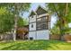 Exterior home view showcasing multiple decks, lush lawn and mature trees and white exterior at 1059 Woodland Ave, Atlanta, GA 30316