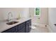 Stylish laundry room with navy cabinets, light quartz countertops, and patterned floors at 1059 Woodland Ave, Atlanta, GA 30316
