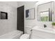 Stylish bathroom with textured tile, a black tile niche, a white vanity, and modern fixtures at 187 Clay Se St, Atlanta, GA 30317