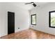 Minimalist bedroom with hardwood floors, two windows with natural light, and dark door and window trim at 187 Clay Se St, Atlanta, GA 30317