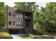 Modern home featuring a unique facade, multiple levels, and a well-manicured lawn with mature trees at 187 Clay Se St, Atlanta, GA 30317