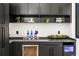 Stylish wet bar features black cabinetry, open shelving, a wine fridge, and elegant decor at 187 Clay Se St, Atlanta, GA 30317