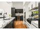 Spacious kitchen features white and black cabinets, stainless steel appliances, marble countertops, and hardwood floors at 187 Clay Se St, Atlanta, GA 30317