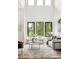Bright living room with soaring ceilings and expansive windows offering serene views of the surrounding greenery at 187 Clay Se St, Atlanta, GA 30317