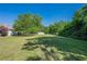 Expansive backyard featuring lush lawn, mature trees, storage building and ample open space at 2492 Bermuda Dr, Loganville, GA 30052