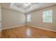 Neutral bedroom with hardwood floors, tray ceiling, and two windows for natural light at 2492 Bermuda Dr, Loganville, GA 30052
