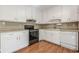 Functional kitchen featuring white cabinets, black appliances, and hardwood flooring at 2492 Bermuda Dr, Loganville, GA 30052