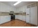 Bright kitchen featuring white cabinetry, stainless steel appliances, and hardwood flooring at 2492 Bermuda Dr, Loganville, GA 30052