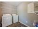 Clean laundry room with white washer, dryer, and wire shelving at 2492 Bermuda Dr, Loganville, GA 30052