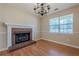 Cozy living area featuring a classic brick fireplace, hardwood floors, and a bright window with natural light at 2492 Bermuda Dr, Loganville, GA 30052