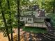 View of the backyard from above the trees featuring a deck, some stone steps, and the side of the house at 4331 Volnay Ne Ct, Marietta, GA 30066