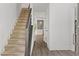 Elegant hallway features a staircase, shiplap walls, and stylish flooring leading to an open-concept kitchen at 4331 Volnay Ne Ct, Marietta, GA 30066