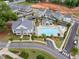 Aerial showcasing community pool with lounge chairs, splash pad, clubhouse, and meticulous landscaping at 1010 Fendley St, Woodstock, GA 30188