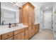 Bright bathroom featuring double vanity, quartz countertops, light wood cabinets, and neutral tile floor at 1010 Fendley St, Woodstock, GA 30188