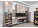 A garage featuring gray cabinetry with ample storage, including shoe racks and overhead units, next to a stainless refrigerator at 1010 Fendley St, Woodstock, GA 30188