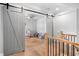 Hallway with sliding barn doors leading to a Bedroom, highlighting modern design elements and natural light at 1010 Fendley St, Woodstock, GA 30188
