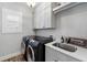 Modern laundry room with new washer and dryer, sink, and cabinetry at 1010 Fendley St, Woodstock, GA 30188