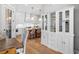 Open-concept living room flows to kitchen with white cabinets and island, hardwood floors, and designer lighting at 1010 Fendley St, Woodstock, GA 30188
