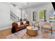 Inviting living room featuring hardwood floors, large windows, and a staircase providing ample natural light and charm at 1010 Fendley St, Woodstock, GA 30188