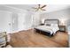 Bright main bedroom boasts wood floors, modern ceiling fan, ensuite bathroom, and abundant natural light at 1010 Fendley St, Woodstock, GA 30188