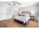 Bright main bedroom with hardwood floors, ceiling fan, dresser, and view of the ensuite bathroom at 1010 Fendley St, Woodstock, GA 30188