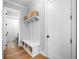 Bright mudroom with a white hall tree featuring hooks, storage, and woven baskets paired with light hardwood flooring at 1010 Fendley St, Woodstock, GA 30188
