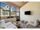 Relaxing screened porch with comfortable wicker furniture and outdoor TV, perfect for entertaining or enjoying quiet evenings at 1010 Fendley St, Woodstock, GA 30188