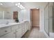 Bathroom featuring dual sinks, white cabinets, a glass enclosed shower and access to the walk-in closet at 2595 Grapevine Cir, Cumming, GA 30041