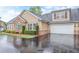 Beautiful exterior featuring a tan siding, brick accents, two-car garage and well-maintained landscaping at 2595 Grapevine Cir, Cumming, GA 30041