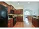 Modern kitchen with dark wood cabinets, stainless steel appliances, and view to living room at 2595 Grapevine Cir, Cumming, GA 30041