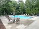 Community pool surrounded by lush greenery and inviting patio furniture at 2595 Grapevine Cir, Cumming, GA 30041