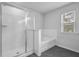 Bathroom with a shower and separate tub, accented by white tile and a window at 2789 Aralynn Way, College Park, GA 30337
