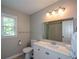 Bathroom featuring a white vanity, toilet, large mirror, and natural light from the window at 3295 Waters Ml, Alpharetta, GA 30022