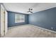 Blue bedroom with large window, carpeted floor, ceiling fan, and a double door closet at 4938 Cedar Lake Ter, Douglasville, GA 30135