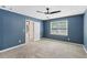 Blue bedroom with a large window, a ceiling fan, and carpeted floors at 4938 Cedar Lake Ter, Douglasville, GA 30135